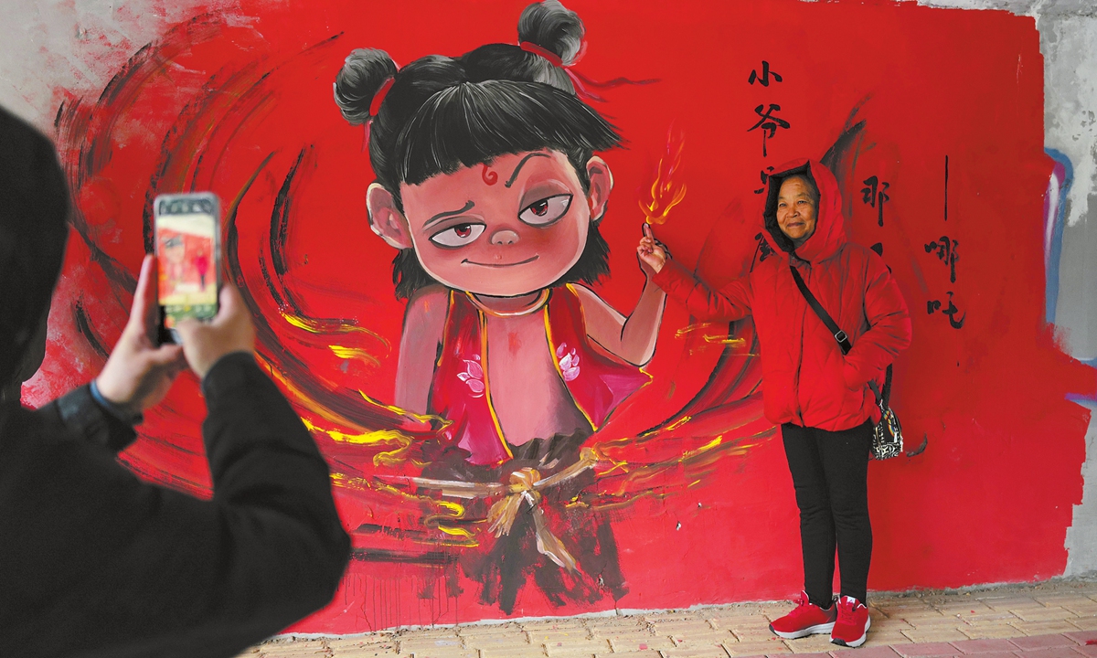 Locals take photos in front of a vibrant Ne Zha-themed graffiti wall that has gained popularity in the Longhua district of Shenzhen, South China's Guangdong Province, on February 16, 2025. Photos on this page: VCG