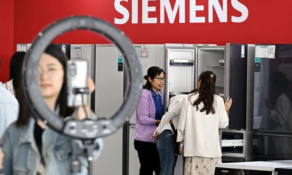 Consumers learn about relevant policies during a consumer goods trade-in event in Qingdao City, east China's Shandong Province, May 17, 2024. (Xinhua/Li Ziheng)