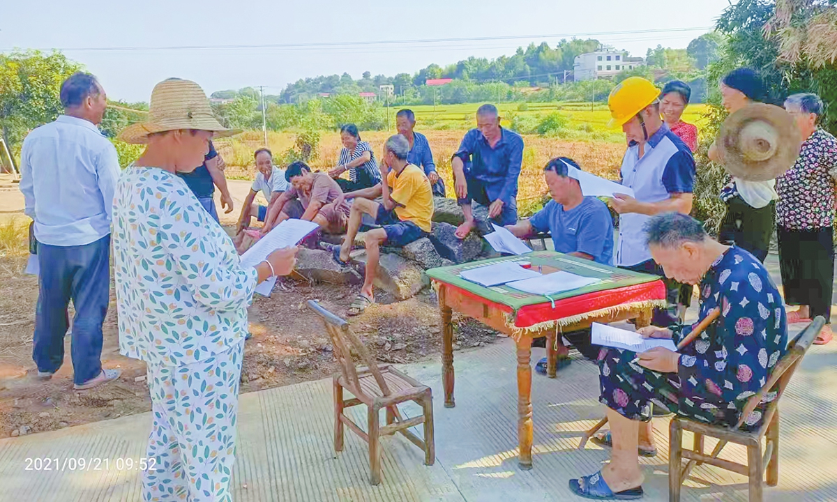 Villagers of Danitang in Central China's Hunan Province read documents explaining policies on the village's collective economic projects. Photo: Courtesy of Xie Jiarong