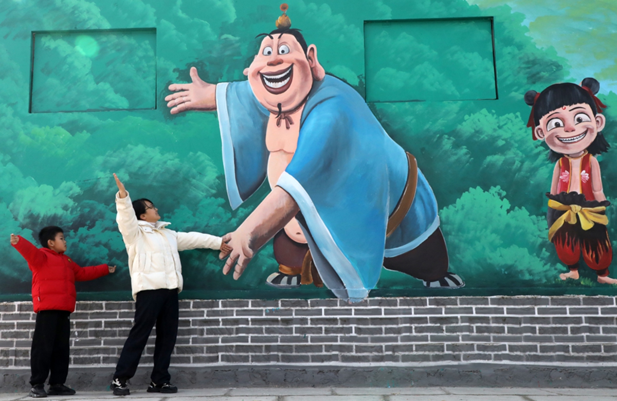 People pose for photos before a mural inspired by the animated film <em>Ne Zha 2</em>in Binzhou, Shandong Province. Photo: VCG